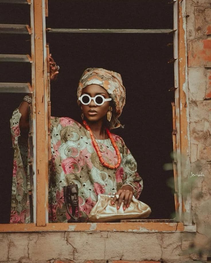 Threads of Time — a model in patterned lace and a headwrap, framed in a window